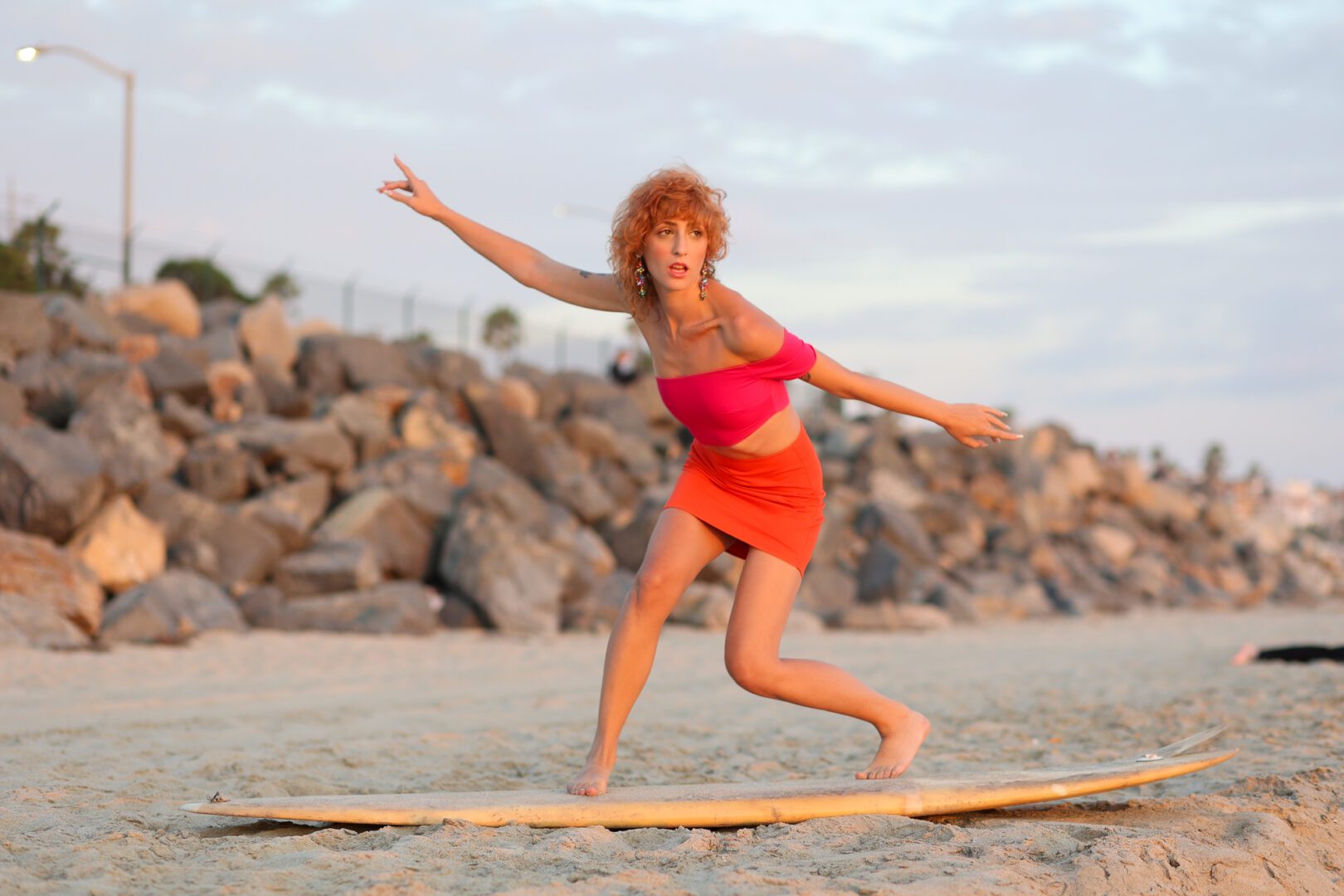 A woman riding a surfboard on a beach.