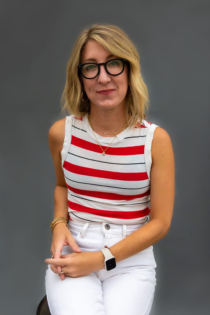 A woman wearing glasses and a red and white striped top.
