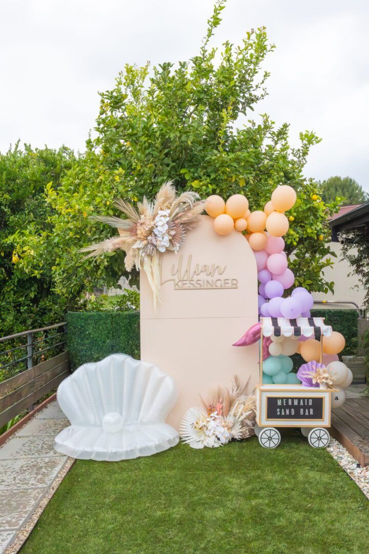 An outdoor party with balloons and a beach theme.