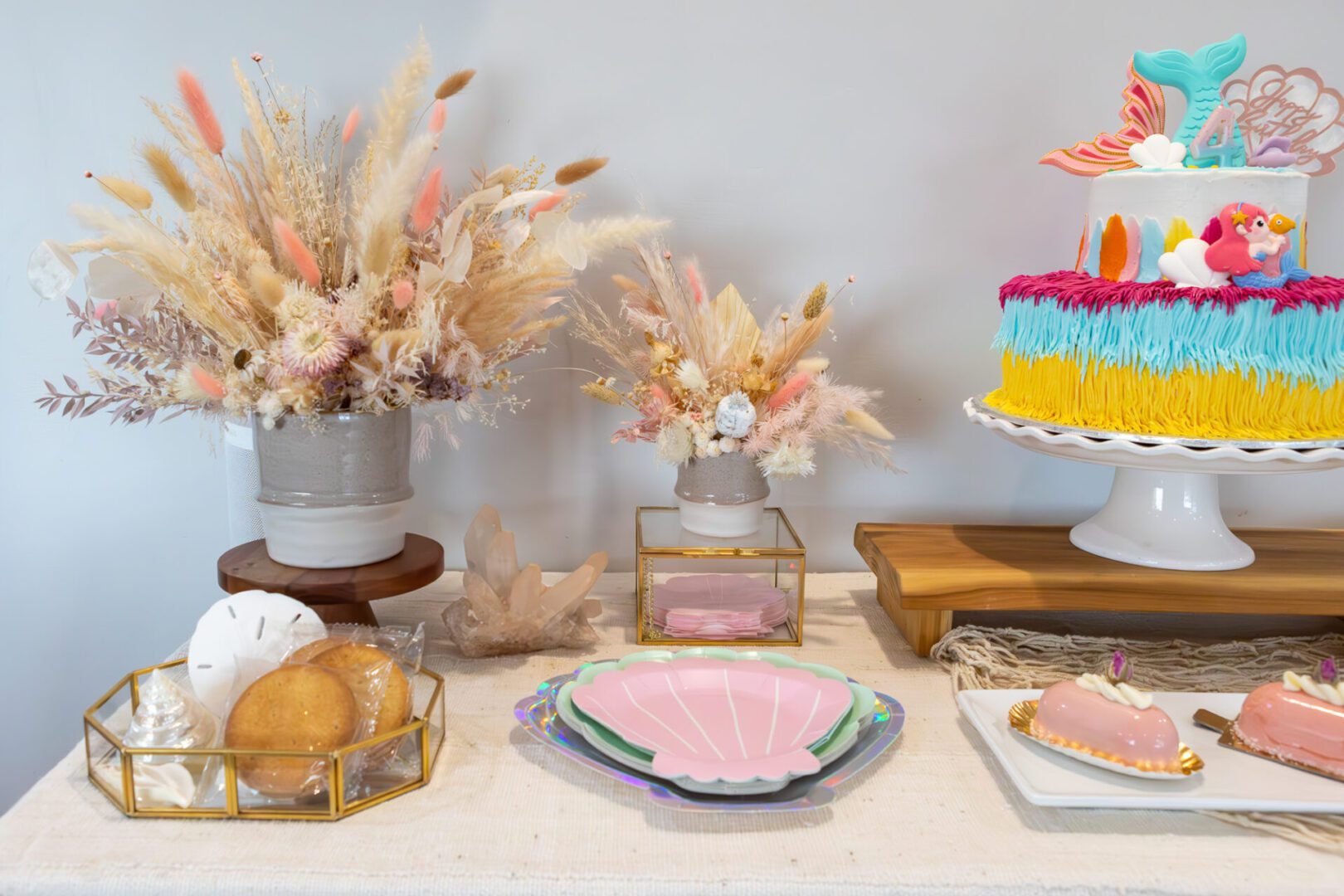 A dessert table with mermaid themed cakes and desserts.