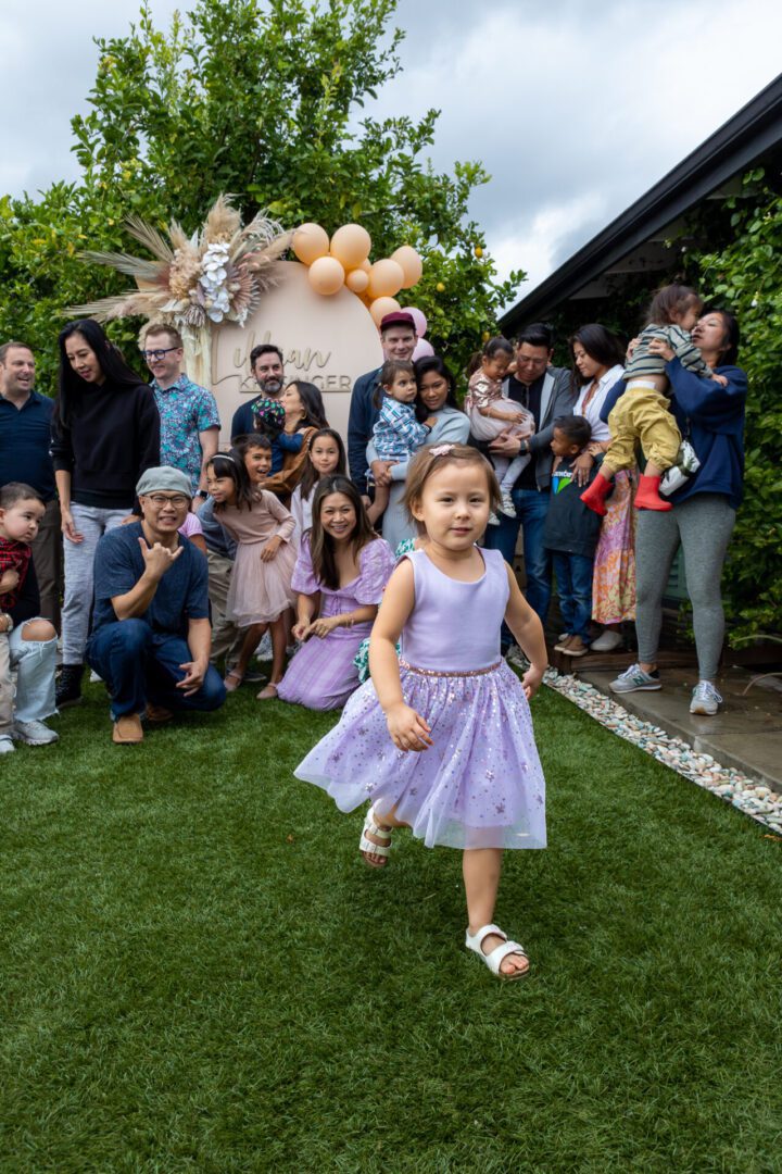 A little girl runs through a crowd of people at a party.