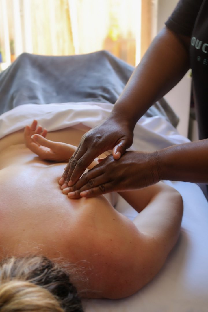 A woman getting a back massage at a spa.